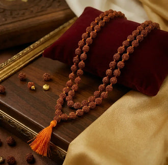 Mukhi Original Rudraksha Mala 108 beads with 1 Guru bead placed on a wooden plate