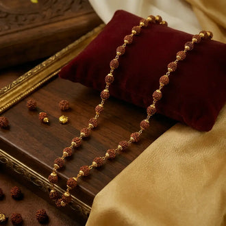 DharmikLife Gold-Plated Rudraksha Mala Necklace with Natural Panch Mukhi Rudraksha Beads Displayed on Velvet Cushion