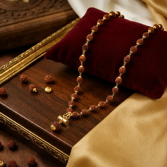 5 Mukhi Nepali Rudraksha Mala with brass Damru and Trishul pendant placed on a wooden plate