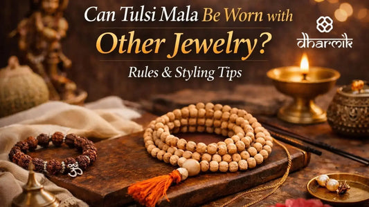 Tulsi mala placed with Rudraksha bracelet, silver and gold jewelry, and a lit diya, showing how Tulsi mala can be worn respectfully with other jewelry.