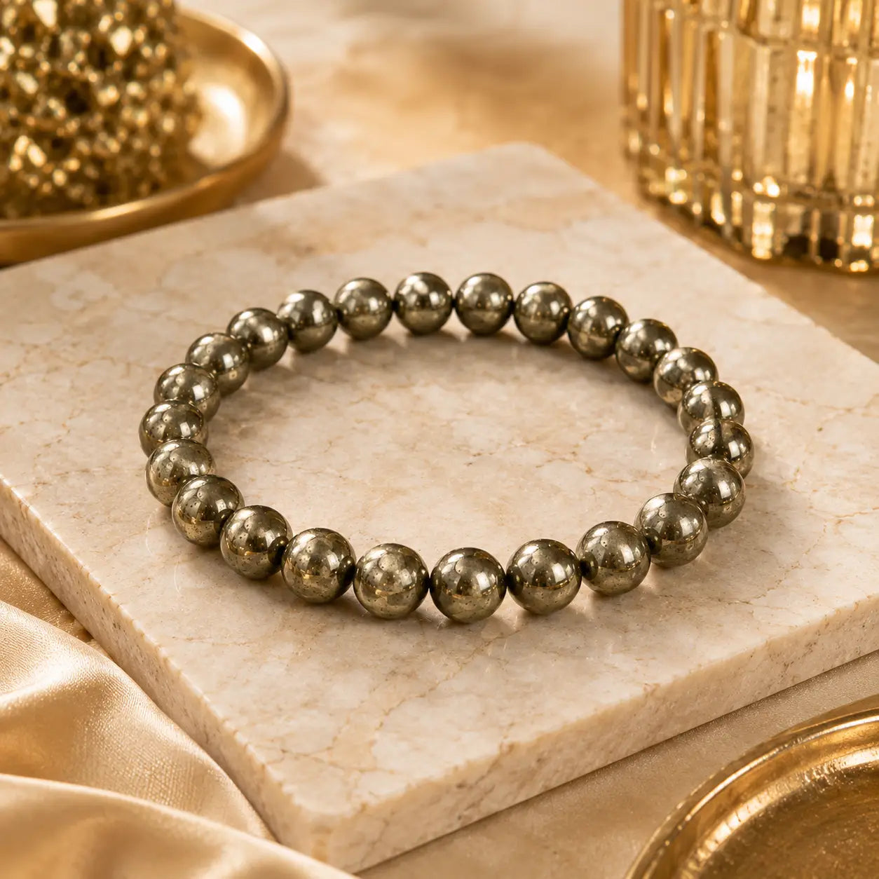 Pyrite bracelet on a marble surface with gold decor elements.