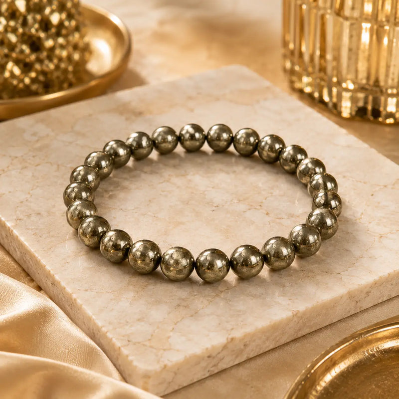 Pyrite bracelet on a marble surface with gold decor elements.
