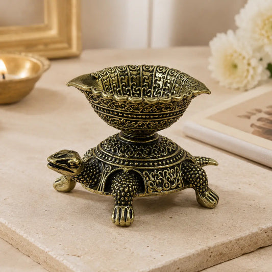 Decorative bronze turtle with a bowl on a marble surface
