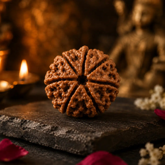  Mukhi Rudraksha bead with seven natural mukhis on a stone slab beside a lit diya