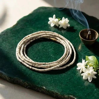 Double round Tulsi Kanthi Mala -8mm  on a green stone surface with incense and white jasmine flowers