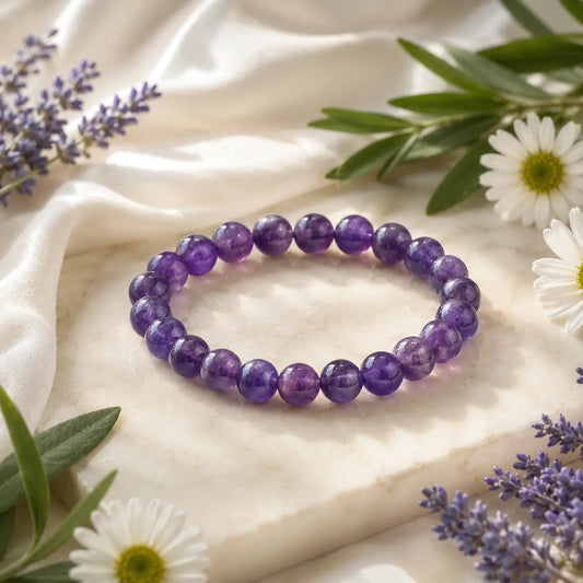amethyst bracelet on a light fabric background with flowers and leaves.