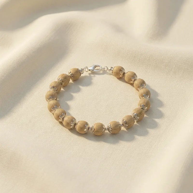 silver plated tulsi mala bracelet 17 beads 10mm, placed on a white cloth