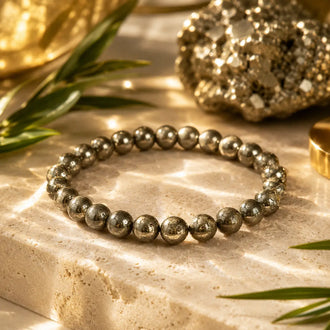 Pyrite beaded bracelet on a textured surface with decorative elements