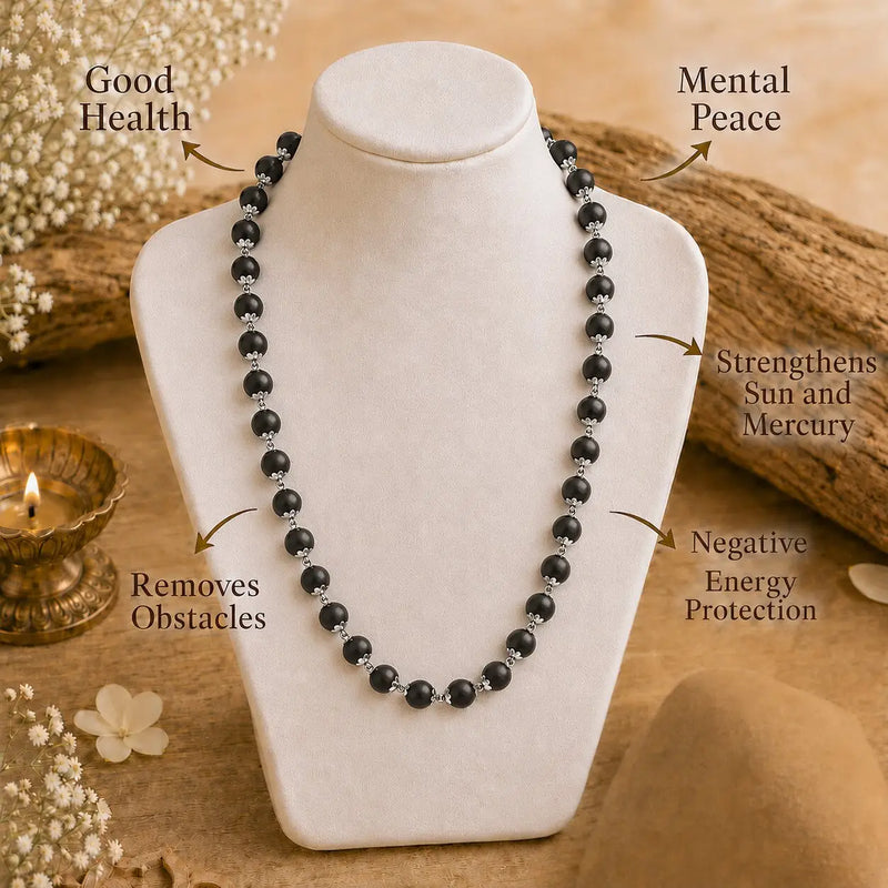 Karungali necklace on a white stand with wellness benefits text, on a wooden surface with decorative elements.