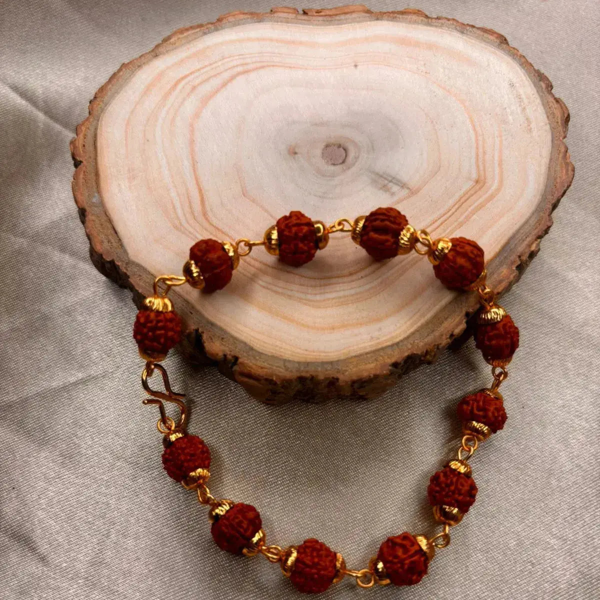 Original Panch Mukhi Rudraksha Bracelet placed on a wooden slice
